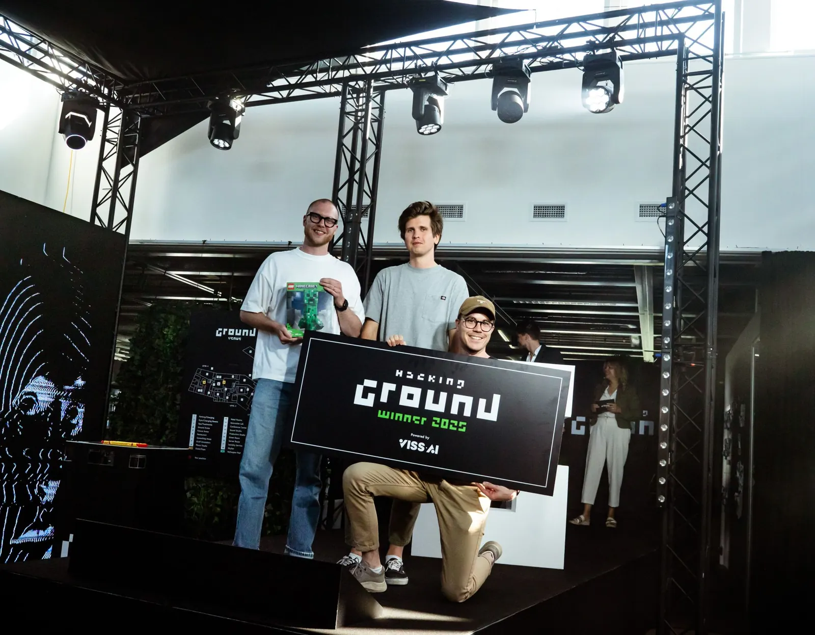 The winning team on stage with the Hacking Ground winner sign